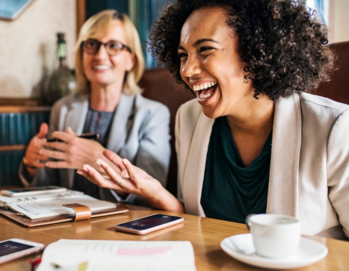 Team collaboration session with designers working on laptop screens showing website layouts and user experience flows